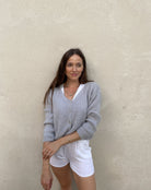 Frau mit brauen Haaren trägt kurze Mohair Strickjacke in hellgrau