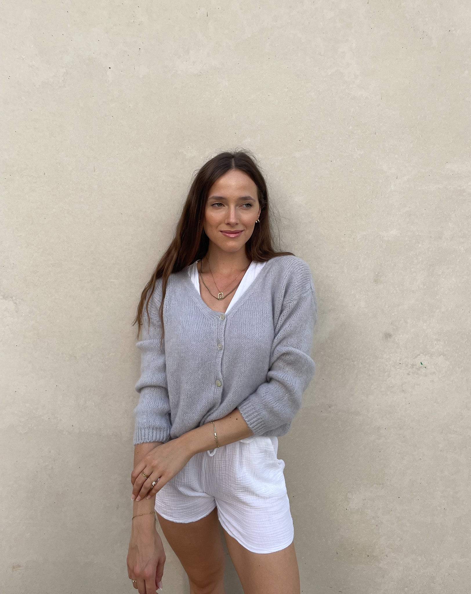 Frau mit brauen Haaren trägt kurze Mohair Strickjacke in hellgrau