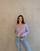 Frau mit brauen Haaren trägt kurze Mohair Strickjacke in flieder