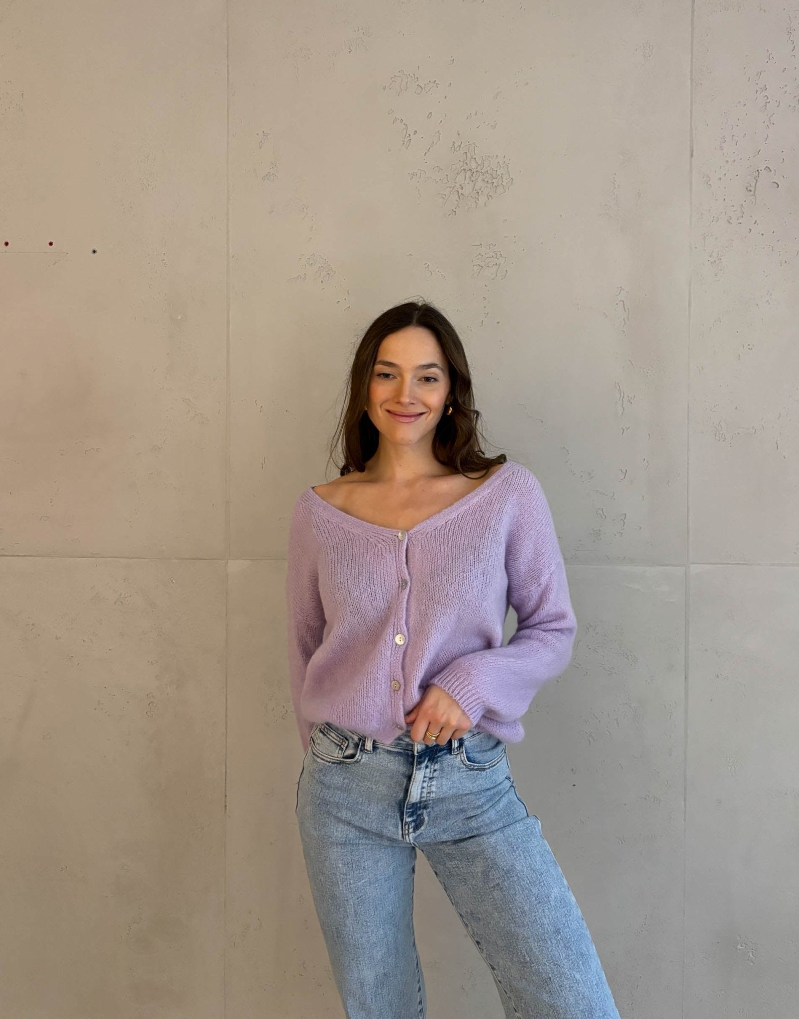 Frau mit brauen Haaren trägt kurze Mohair Strickjacke in flieder