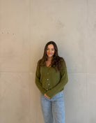 Frau mit brauen Haaren trägt kurze Mohair Strickjacke in grün