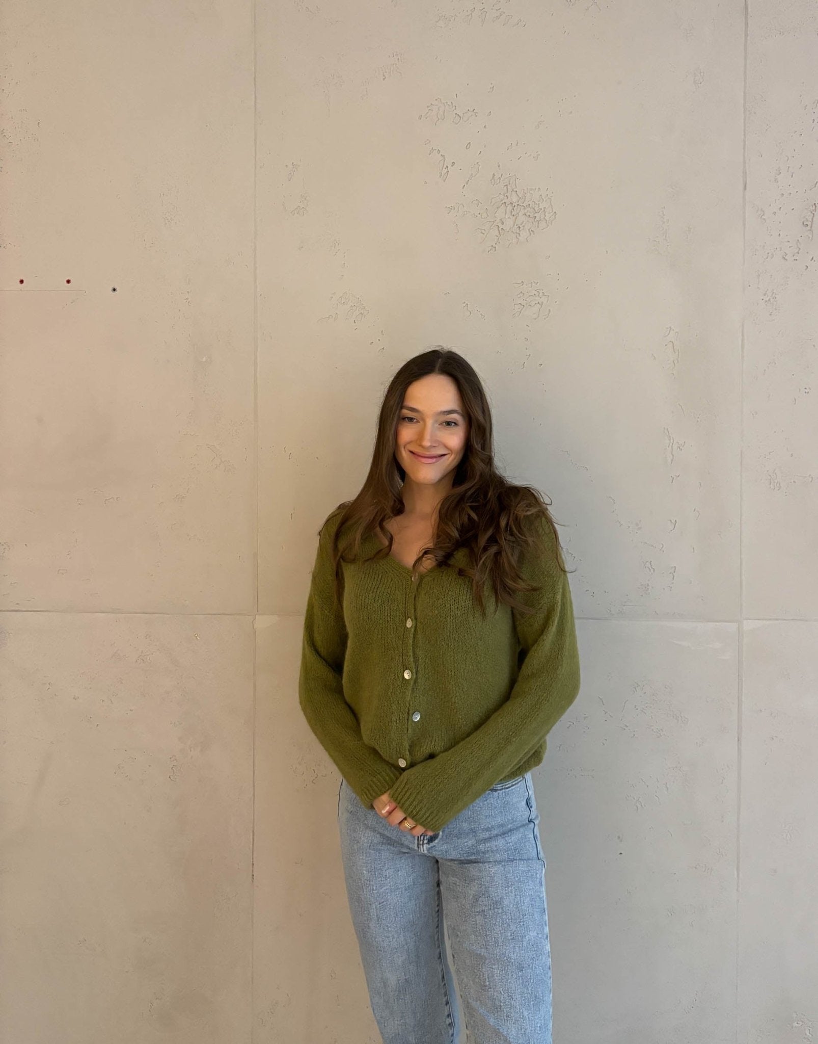 Frau mit brauen Haaren trägt kurze Mohair Strickjacke in grün