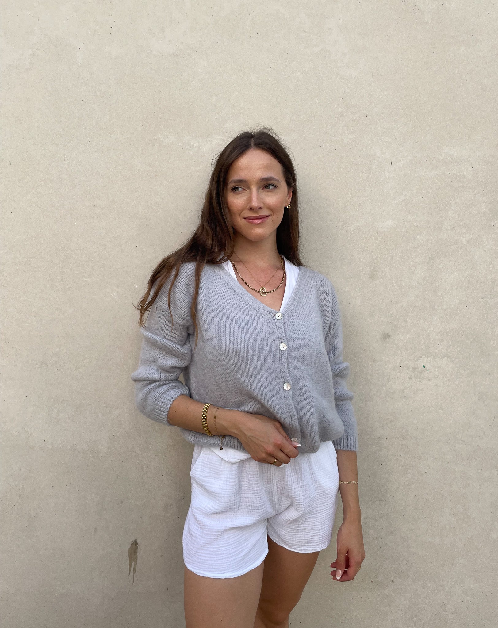 Frau mit brauen Haaren trägt kurze Mohair Strickjacke in hellgrau