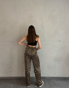 Frau mit braunen Haaren trägt silky Leo hose in gold 