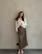 Frau mit brauen Haaren trägt silky Leo Rock in Gold/Braun 