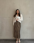 Frau mit brauen Haaren trägt silky Leo Rock in Gold/Braun 