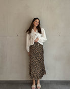 Frau mit brauen Haaren trägt silky Leo Rock in Gold/Braun 