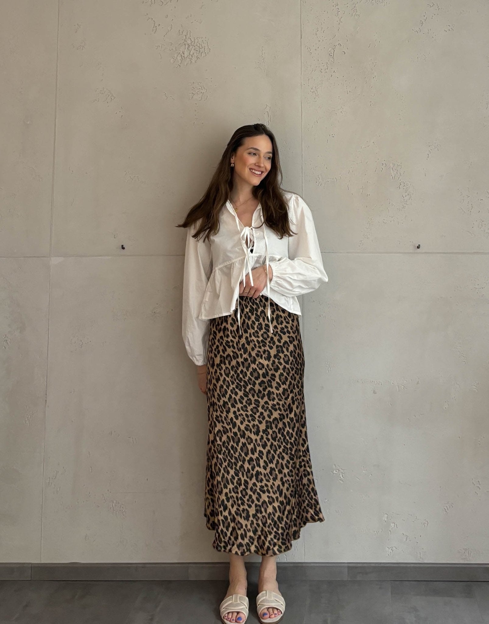 Frau mit brauen Haaren trägt silky Leo Rock in Gold/Braun 