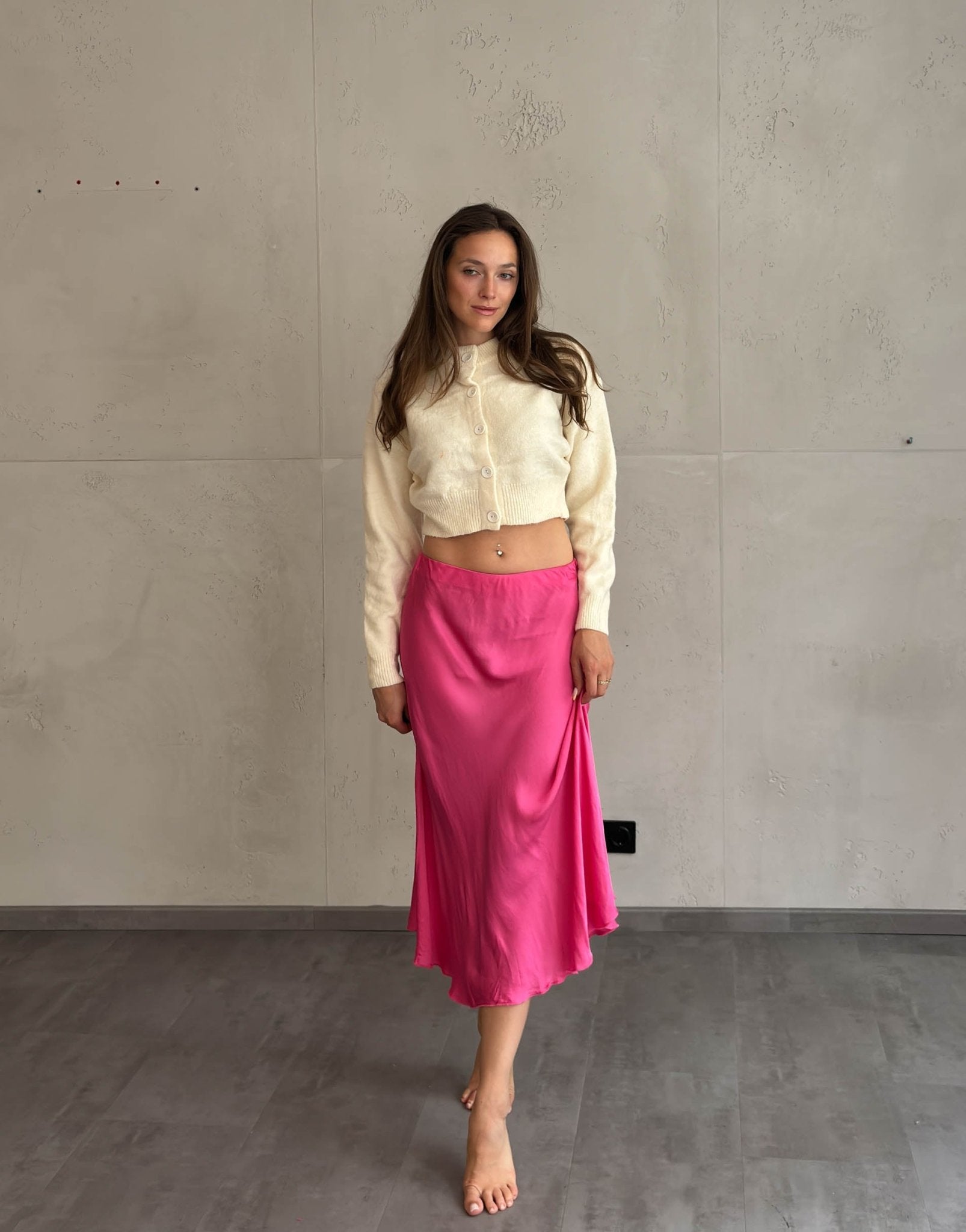 Frau mit braunen Haaren trägt Midi Silky Rock in Pink