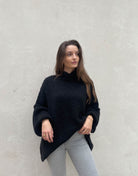 Frau mit brauen Haaren trägt oversize Pullover in Schwarz