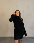 Frau mit brauen Haaren trägt schwarzes Strickkleid in schwarz 