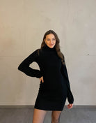 Frau mit brauen Haaren trägt schwarzes Strickkleid in schwarz 