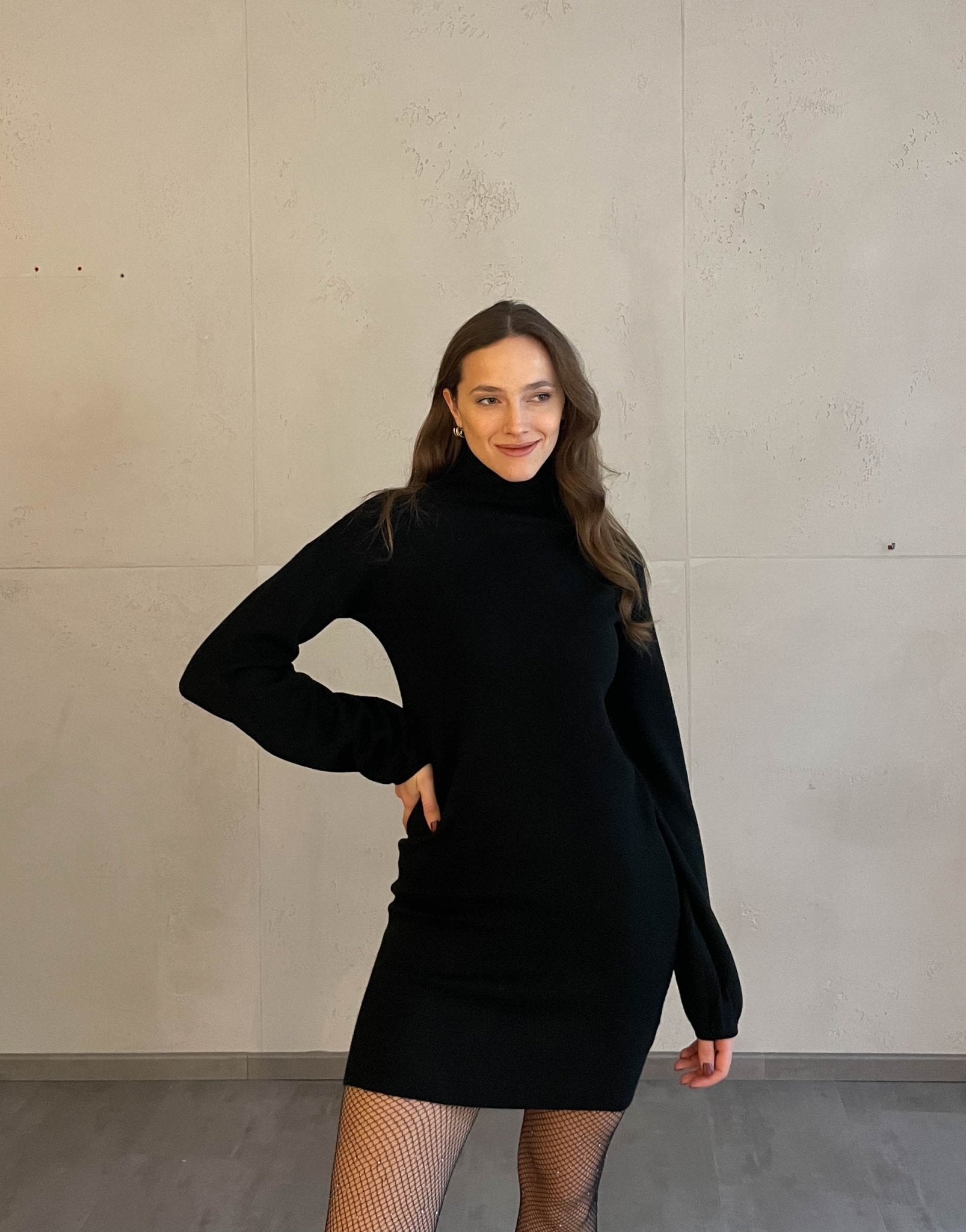 Frau mit brauen Haaren trägt schwarzes Strickkleid in schwarz 