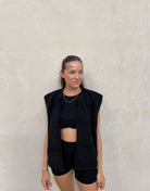 Frau mit brauen Haaren trägt Teddy Weste in Schwarz