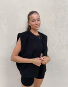 Frau mit brauen Haaren trägt Teddy Weste in Schwarz