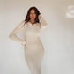 Frau mit brauen Haaren trägt Strickkleid in Beige